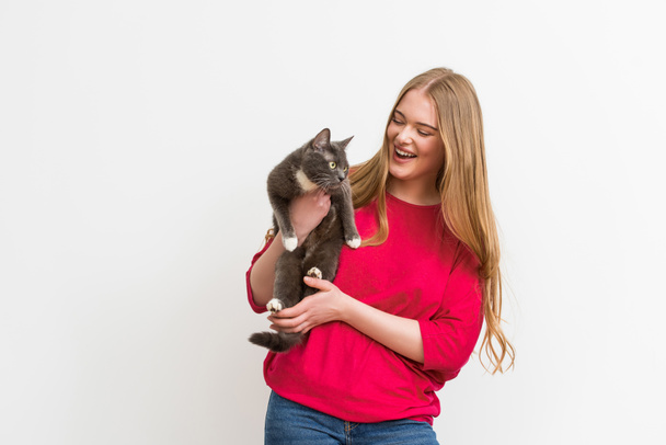 cheerful woman holding in arms fluffy cat isolated on white  - Fotó, kép