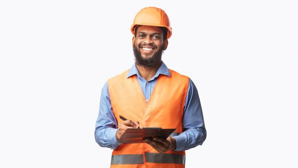 Glücklicher Bauarbeiter Guy nimmt Notizmappe in die Hand, Studioaufnahme - Foto, Bild