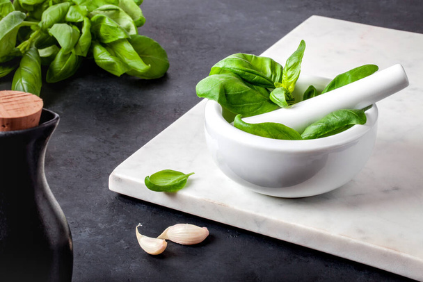 Basil leaves, garlic and olive oil on the table. - Fotografie, Obrázek