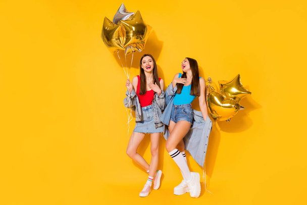Full length body size view of nice attractive pretty lovely slender cheerful cheery glad girls holding in hands air balls having fun isolated on bright vivid shine vibrant yellow color background - Foto, imagen
