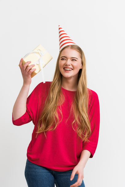 happy girl in party cap holding present isolated on white  - Фото, зображення