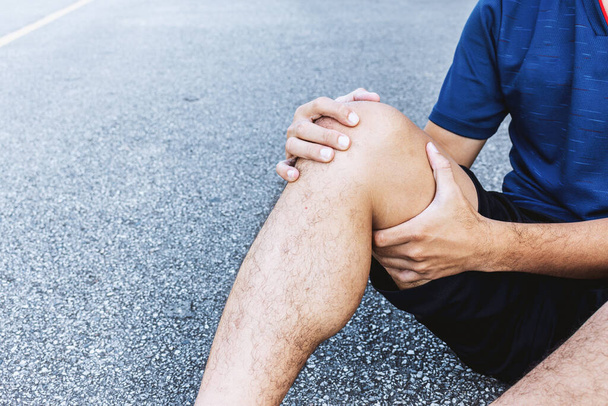 Крупный план спортсмен травмы колена от бега с мягким фокусом и над светом на заднем плане
 - Фото, изображение