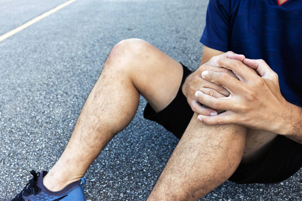 közelkép sport férfi térd sérülések futás lágy fókusz és több mint fény a háttérben - Fotó, kép
