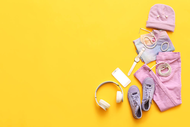 Female accessories with clothes, headphones and mobile phone on color background - Foto, immagini