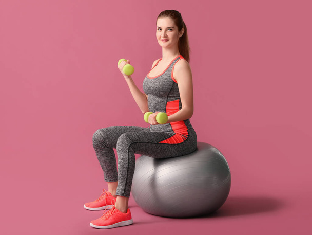 Sporty young woman training on color background - Foto, afbeelding