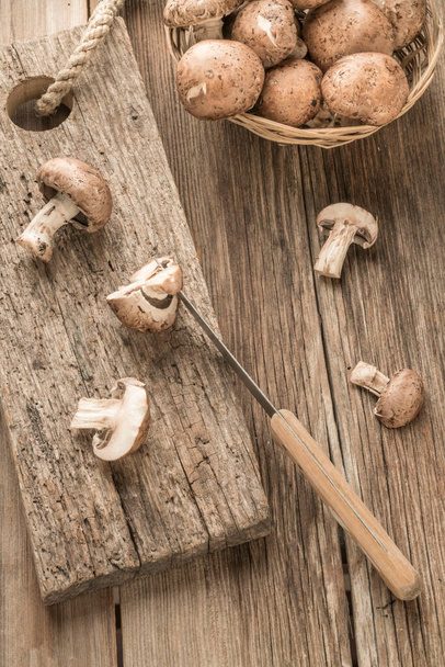 gesneden champignons op een houten snijplank op tafel - Foto, afbeelding