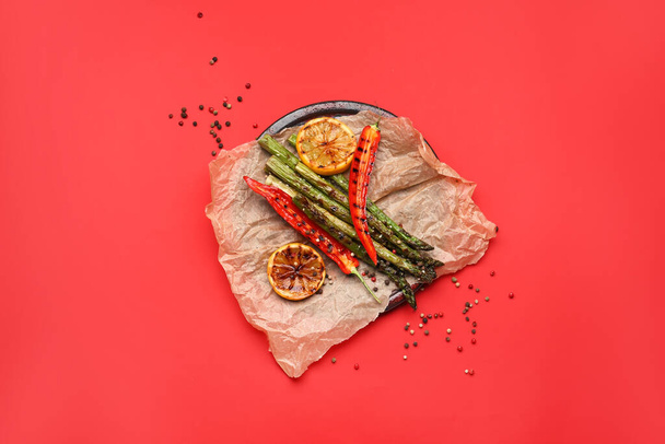 Gekookte asperges met chili peper en citroen op kleur achtergrond - Foto, afbeelding