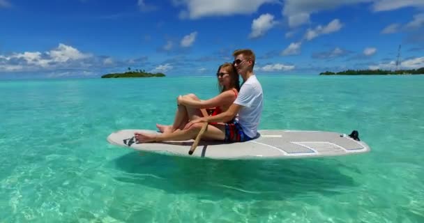 Jovens casais na prancha surfando juntos no mar azul-turquesa na República Dominicana - Filmagem, Vídeo