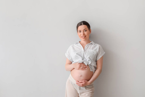 Beautiful pregnant woman on light background - Фото, изображение