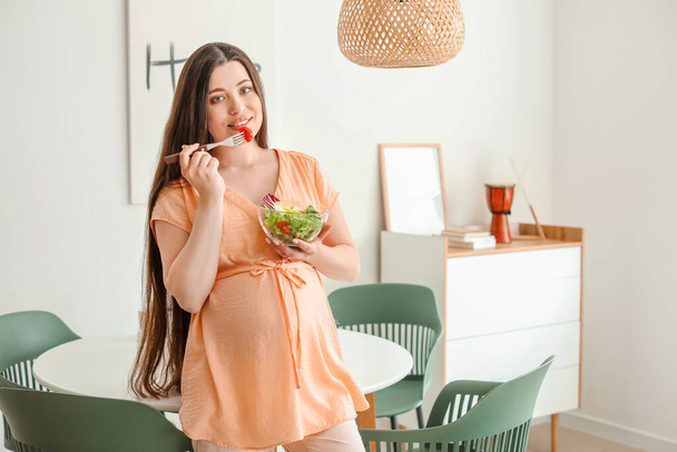 Красивая беременная женщина со здоровым салатом дома
 - Фото, изображение