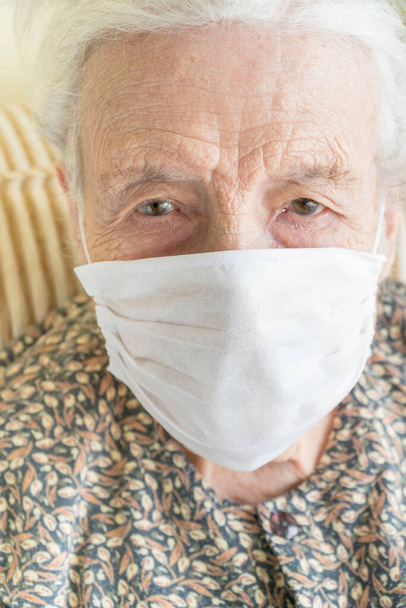 A senior woman wearing medical mask for protection of covid19 virus - Foto, Imagen