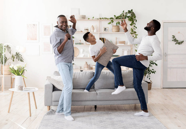 Trzy pokolenia mężczyzn bawiących się razem w domu, - Zdjęcie, obraz