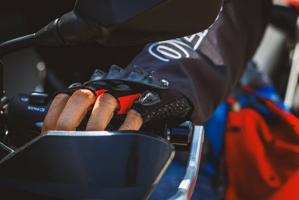 closeup male hands holding handlebar of motorcycle bigbike with soft-focus and over light in the background - Φωτογραφία, εικόνα