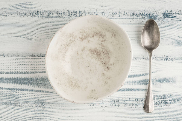 an empty and clean ceramic bowl and spoon on a table - Foto, immagini