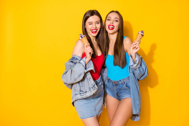 Portrait of nice-looking attractive glamorous lovely fashionable funky cheerful cheery girls eating icecream having fun isolated on bright vivid shine vibrant yellow color background - Фото, зображення