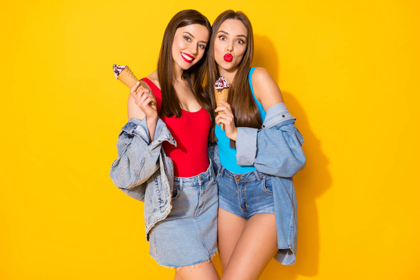 Portrait of positive cheerful buddies girl have fun on summer spring weekend walk hold tasty yummy scoops ice cream wear tank-top denim isolated over shine color background - 写真・画像