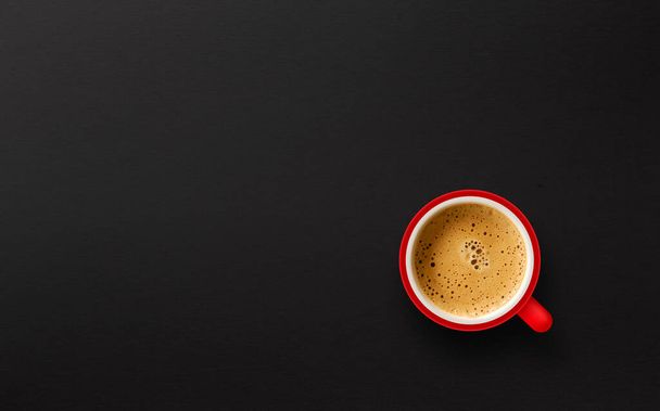 rote Tasse Kaffee auf schwarzem Papier Hintergrund. Ansicht von oben - Foto, Bild