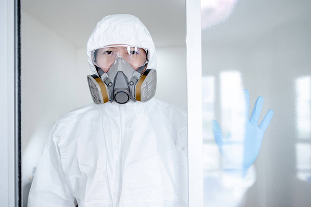 Επιστήμονας ή ιολόγος άνθρωπος φορώντας στολή βιολογικού κινδύνου, γυαλιά και μάσκα. Άνδρας γιατρός ή ιατρός που φοράει ΜΑΠ και λαστιχένια γάντια για την πρόληψη της λοίμωξης από τον ιό του κερατοειδούς (COVID-19). - Φωτογραφία, εικόνα