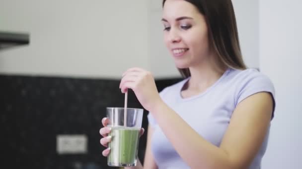 La mujer bebe el batido de hortalizas de las frutas con la leche a través de la paja
 - Metraje, vídeo