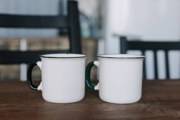 Two coffee cups on wooden table in the kitchen  - Photo, image