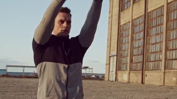 Young and fit man having evening workout outdoor. Urban sunset background. Fitness and sport concepts. - Materiał filmowy, wideo