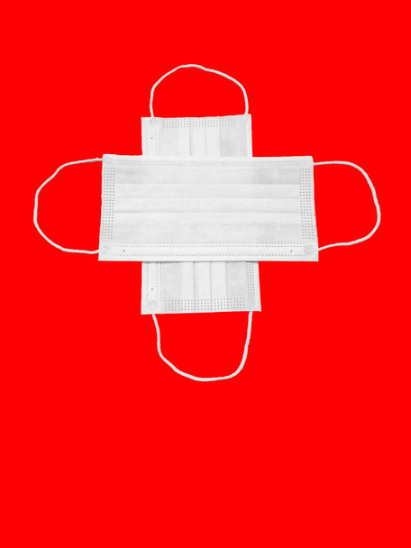 Eine medizinische Maske isoliert auf rotem Hintergrund. Raum für Text. - Foto, Bild