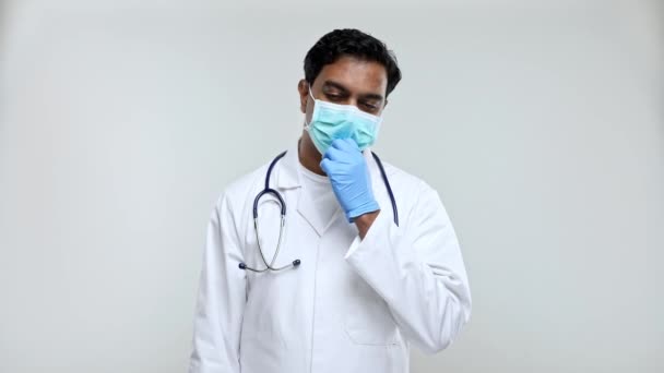 Doutor tirando máscara médica após o trabalho Smilling. indiano homem médico isolado médico máscara e luvas
. - Filmagem, Vídeo