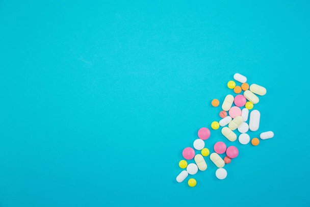 Куча разноцветных таблеток на синем фоне
 - Фото, изображение