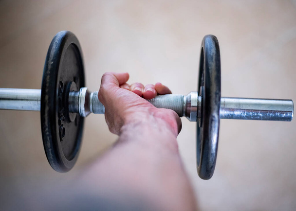 play sports at home. Cut view of a hand holding a dumbbell weight - Photo, Image