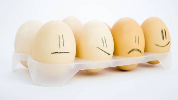 Eggs in a tray with sad emotions. - Φωτογραφία, εικόνα