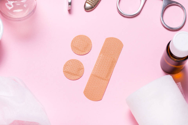 Set of adhesive bandage, medical sticking plaster on pink backgr - Photo, image