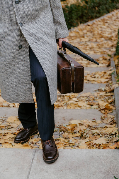 Men's autumn fashion. Man in stylish shoes and a white coat - Foto, Imagen