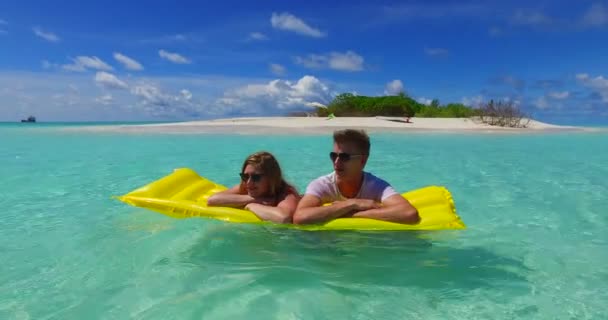Prachtige maagdelijke oever van de blauwe zee en wit zandstrand. Paar ontspannen op vakantie in de Malediven. - Video