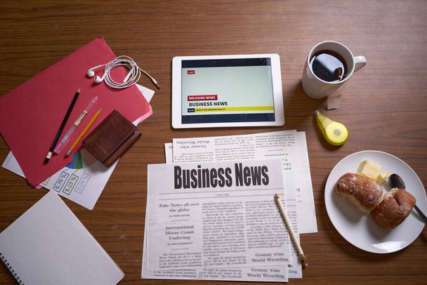 Noticias de negocios, Periódico sobre la mesa, café de la mañana, noticias financieras
            - Foto, imagen