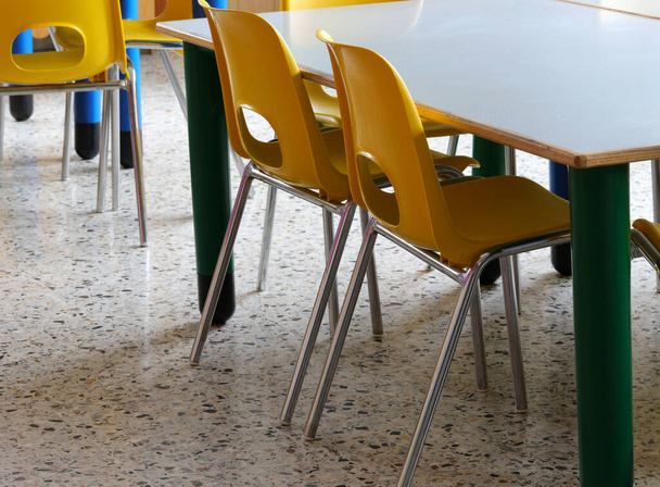 İlkokulda sarı plastik sandalyeli çocukların olmadığı bir sınıf. - Fotoğraf, Görsel