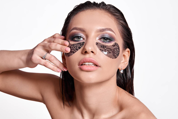 Face care at home. Beautiful woman with professional make-up and eye patches - Φωτογραφία, εικόνα