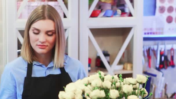Młoda kobieta kwiaciarnia rozmawia z klientem - Materiał filmowy, wideo