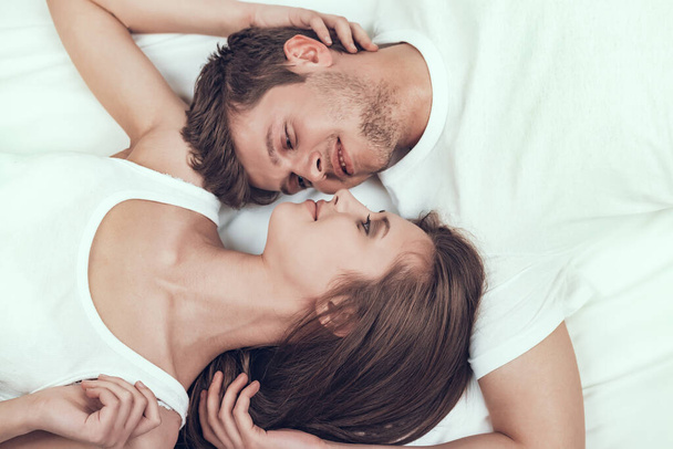 Honeymoon Couple is Lying in Bed and Smiling. - Valokuva, kuva
