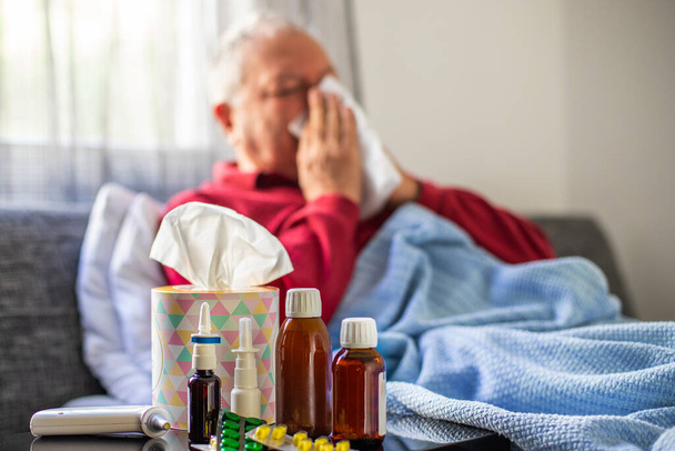 Yaşlı bir grip hastası yatakta yatıyor. Yatak odasında yatak ve battaniyeli hastalık konsepti. - Fotoğraf, Görsel