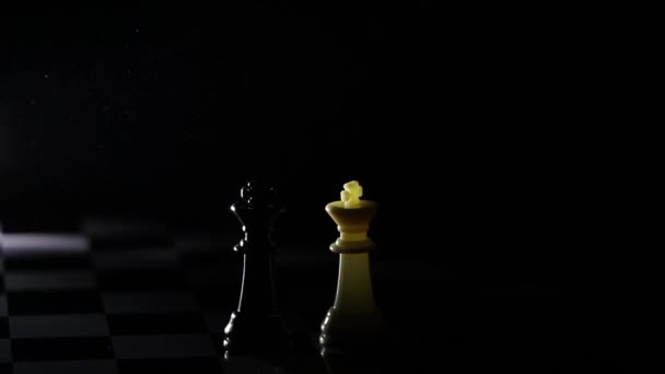 Schachfiguren auf einem Schachbrett in einem dunklen Raum, der von einer Laterne beleuchtet wird - Filmmaterial, Video