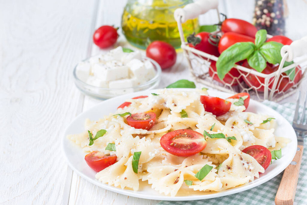 Pasta salad with tie pasta, feta cheese, cherry tomatoes, mustard and basil, copy space, horizontal - Fotoğraf, Görsel
