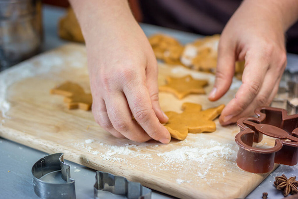 Woman makes christmas gingerbread cookies. Dough and metal cutters on a wooden table, horizontal - Fotoğraf, Görsel