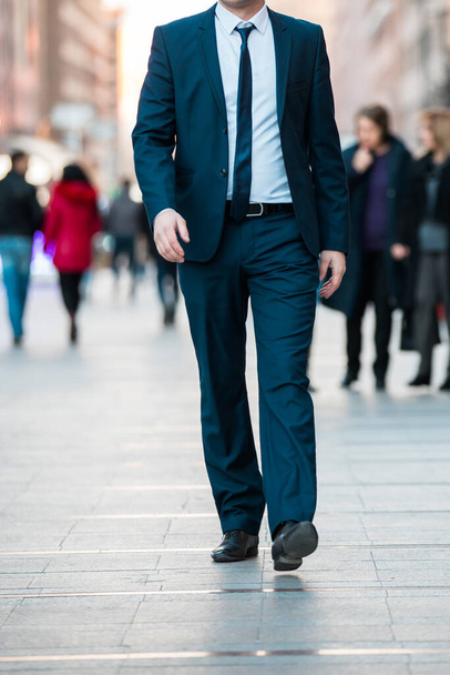 Handsome young businessman walking on city street  - Фото, зображення