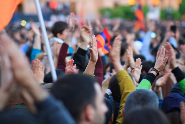 Az egyesült emberek tömegei felemelik a kezüket a belvárosban..  - Fotó, kép