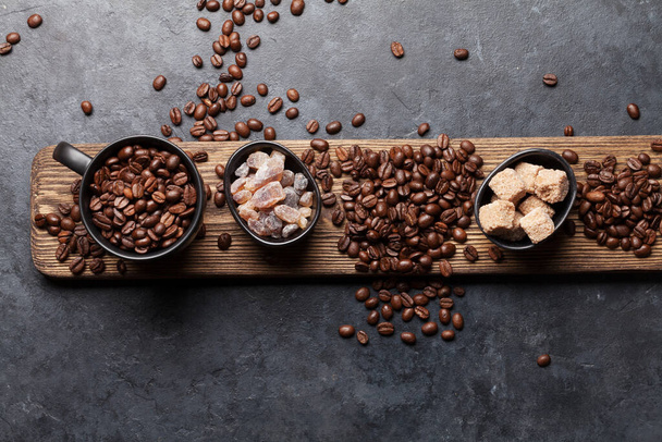 Xícara de café, açúcar e grãos torrados na mesa de pedra escura. Vista superior com espaço de cópia. Depósito plano - Foto, Imagem