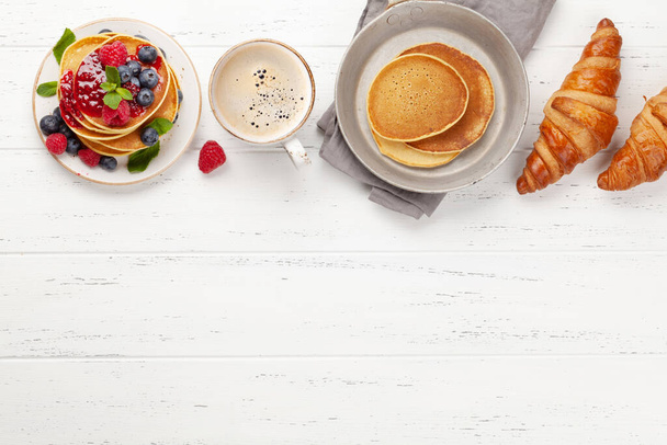 Delicious homemade pancakes with summer berries and coffee for breakfast. Top view with copy space - Fotoğraf, Görsel
