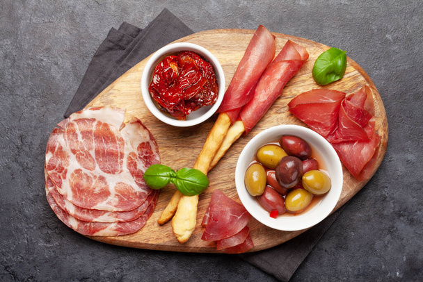 Cheese, meat and olives antipasto. Appetizer selection on wooden board. Top view. Flat lay - Foto, imagen