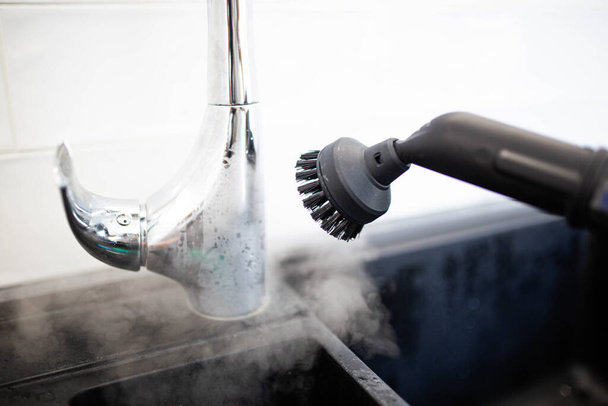cleaning the sink and faucet with a steam cleaner, disinfection in the house. - Foto, Bild