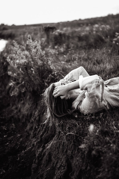 Yerde yatan güzel bir kızın yakın plan portresi. Adamın eli kıza dokunuyor. El ele. El ele tutuşun - Fotoğraf, Görsel