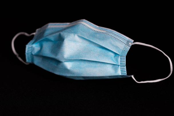 close-up of a blue surgical mask isolated on black background - Photo, Image